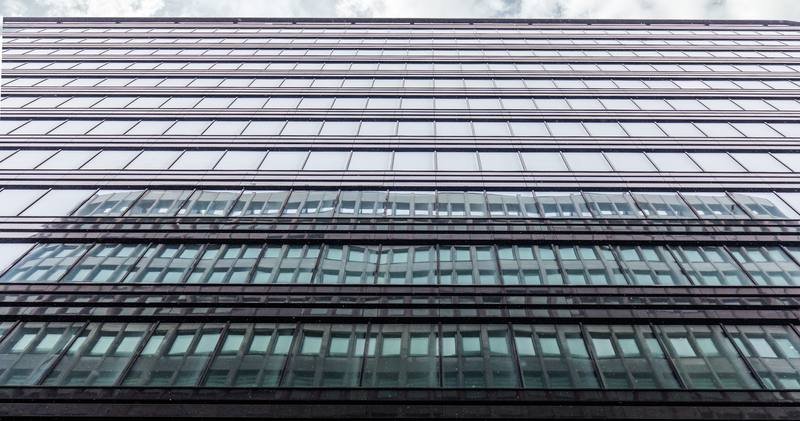 Fachada acristalada de un edificio de oficinas vista desde abajo
